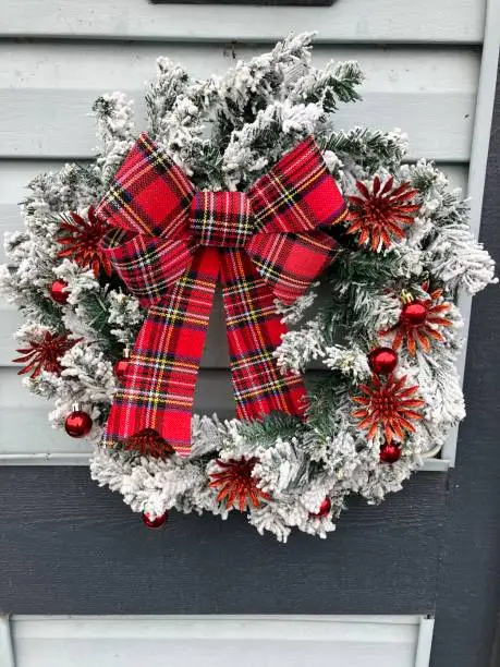 Photo of Christmas wreath with red bow, snow wreath, winter wreath