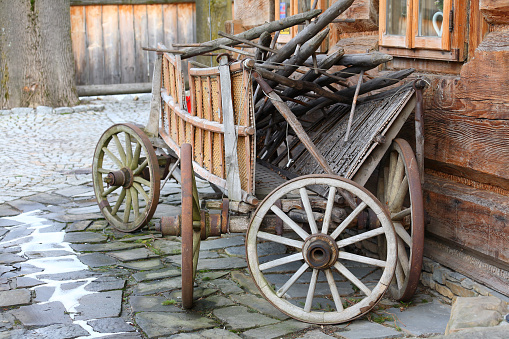 Zakopane, Poland - March 09, 2016, Wooden cart in front of the wall of the building, built in the traditional way with logs. This scene recalls the tradition of the region.