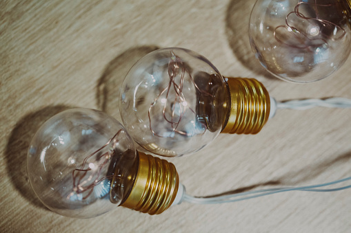 Some old light bulbs shining on a wooden background close up