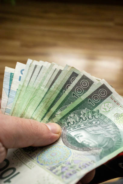 istock A hand securely holding a Polish banknote for a business transaction. 1958207893