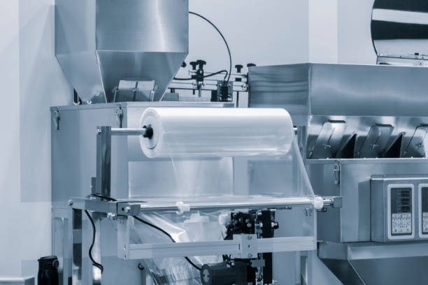 istock Automatic polyethylene plastic bag production machine with lighting effect. Close-up of the roller of the plastic bag production machine in the light blue scene. product packaging concept 1958224837