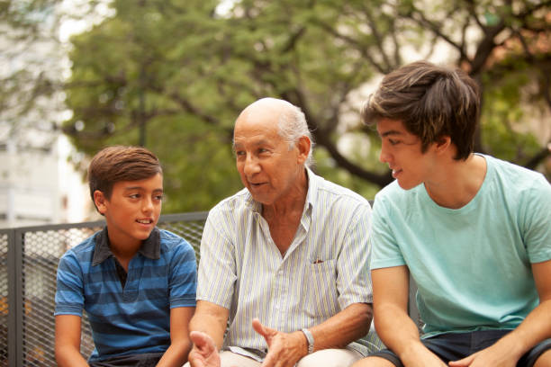 Grandfather and grandsons talking outdoors