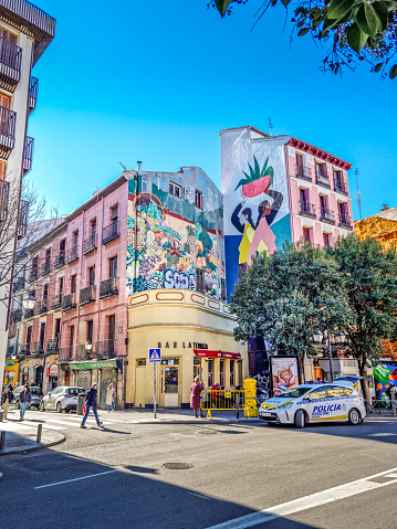 Madrid, Spain - 05 February, 2023: People walking by the El Pilar mural art. The art is located in the Plaza de Puerta Cerrada and was painted by the Mexican artist Hilda Palafox.