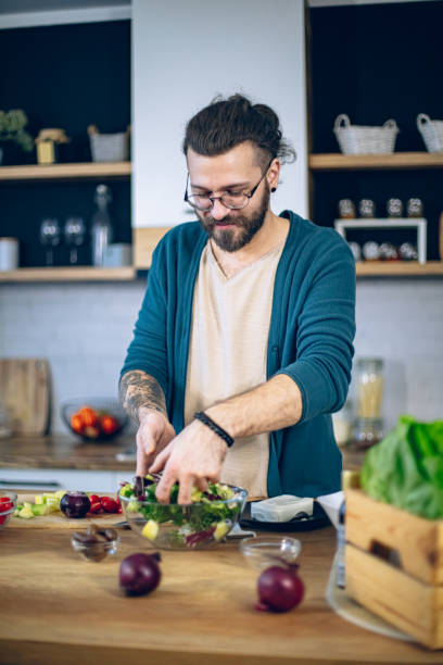 istock Man is preparing a salad in the kitchen 1958249698