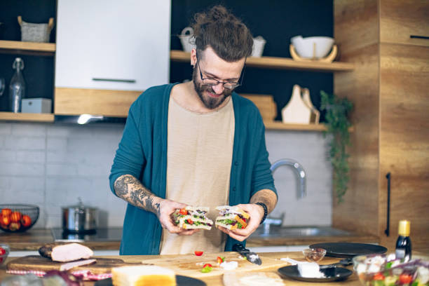istock Man prepares a club sandwich in the kitchen 1958251764