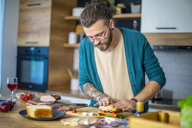 istock Man prepares a club sandwich in the kitchen 1958262703