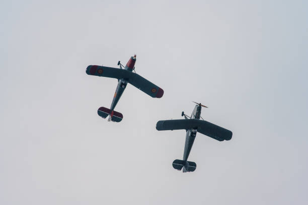 Hawker Nimrod Biplane in cloudscape setting, vicinity of Duxford, Camdridgeshire, England. Solo classic wartime single seat fighter aircraft flying in moody sky cloudscape over the fields of England