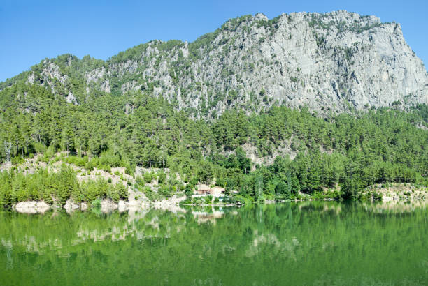 The panoramic view of green color Karacaoren Lake with a tall mountain in Antalya province (Turkey).