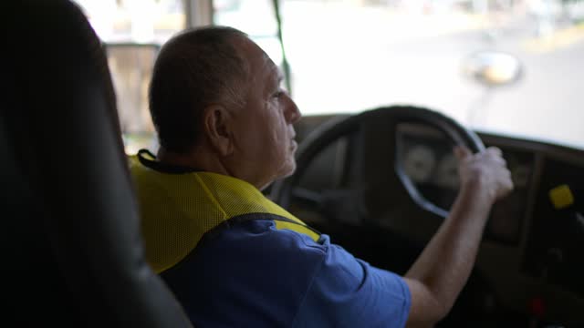 Senior bus driver man driving a bus on the city