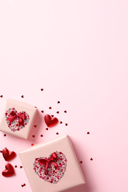 istock Valentine's Day vertical banner with gift boxes, hearts, and confetti on pink background. 1958323043