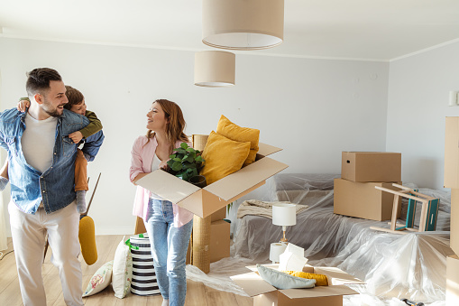 Happy Caucasian family with one little boy starting new life in new apartment