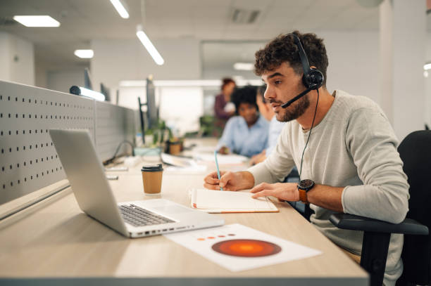 istock A virtual assistant is sitting at call center department and working. 1958337063