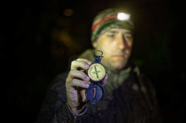 istock Explorer traveler man looking at his compass during night walk. 1958341473