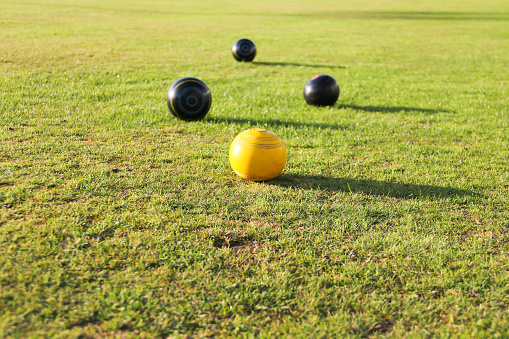 Crown green bowling- bowls on green surrounding the yellow Jack, a great competition enjoyed by many seniors and young people alike.