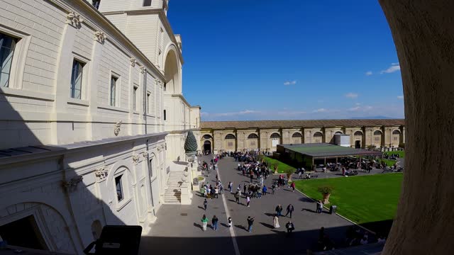 Cinematic view of tourist people visiting courtyard of the Pigna, Vatican museum, Vatican city, Rome, Italy in summer sunny day