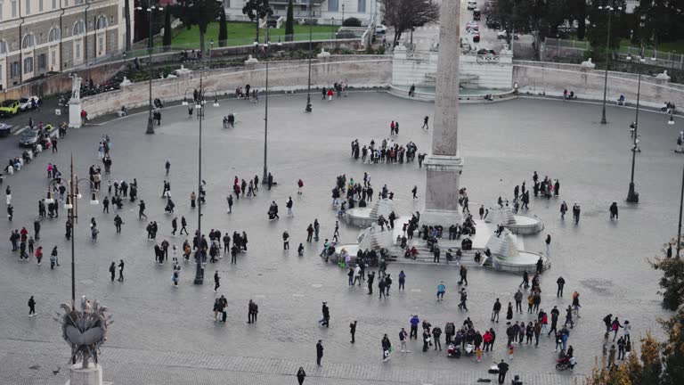 Cinematic view of crowd of tourists people at Egyptian obelisk fountain at visit of the People's Square, Piazza del Popolo, slow motion