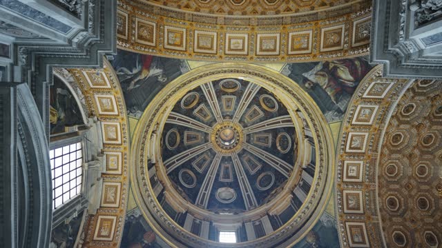 Interior view and looking up into a church Dome with murals, painting and stucco on walls and ceiling in Saint Peter basilica in Vatican, Rome, Italy
