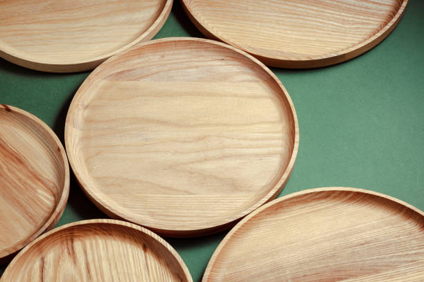 istock Wooden flat plates on a green background. Products for modern kitchen. 1958407447
