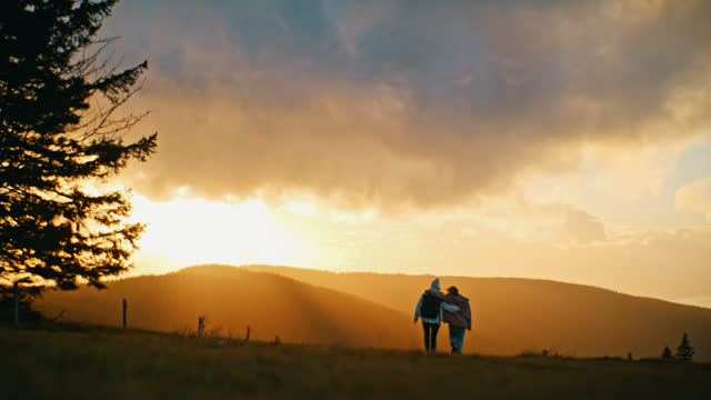 SLOW MOTION Young Women Hiking In Remote Field With Scenic Mountain View At Sunrise
