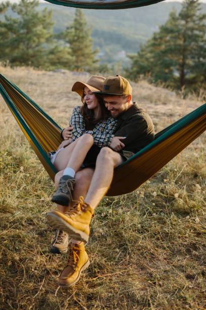 istock A couple in love are hugging while lying in a hammock in nature. 1958454431