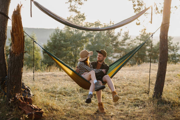 istock Happy couple in love enjoying the sunset outdoors while relaxing in a hammock. 1958454446