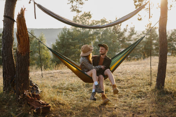 istock Happy couple in love enjoying the sunset outdoors while relaxing in a hammock. 1958454448