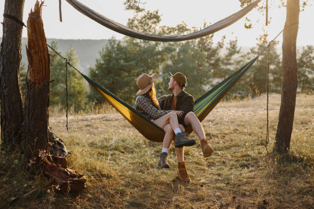 istock Happy couple in love enjoying the sunset outdoors while relaxing in a hammock. 1958454797