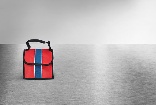 Red and blue lunch bag on an industrial metallic background
