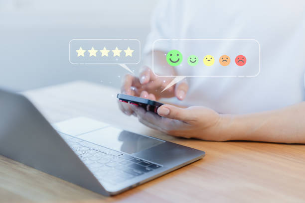 istock Male hand using a mobile phone with virtual screen on happy smile face icon to give satisfaction in service. Opinion rating very impressed. Assessment testimonial customer service and feedback concept 1958531296