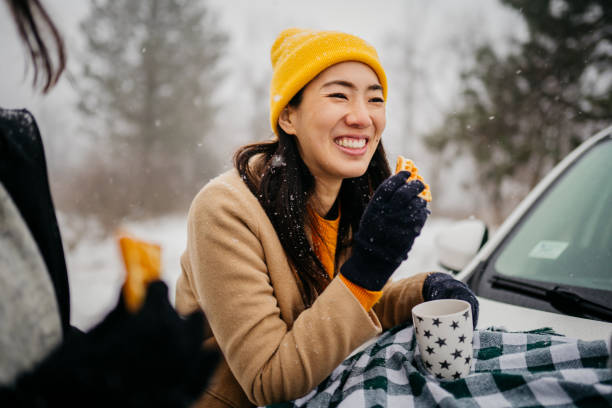 Picnic on a car trunk Two cheerful female friends having fun on a snowy day in a park happy car asian stock pictures, royalty-free photos & images