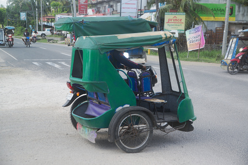 Cebu , Pilippines - January 27,2020 : Three-wheeled vehicles on the road, called Tatlong-wiler motorized tricycles. How to transport passengers everywhere in the Philippines on January 27,2020.