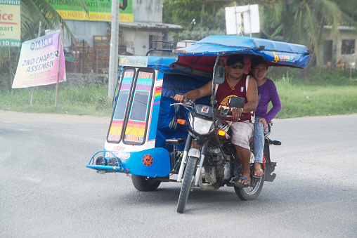 Cebu , Pilippines - January 27,2020 : Three-wheeled vehicles on the road, called Tatlong-wiler motorized tricycles. How to transport passengers everywhere in the Philippines on January 27,2020.