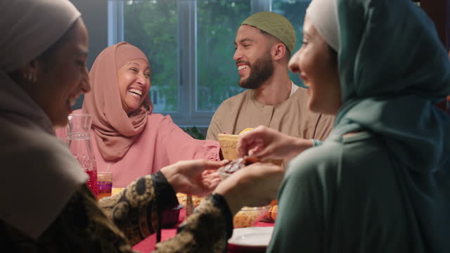 Muslim, happy and family with food in home for Eid Mubarak celebration, Ramadan and holiday. Laugh, festive event and Islam parents, son and daughter for supper, dinner and eating lunch for bonding