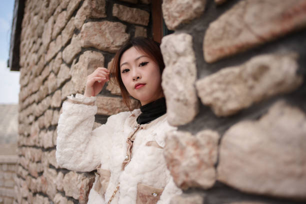 young woman by stone wall