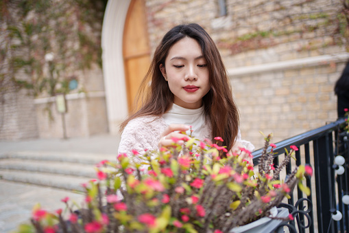 Asian woman admiring flowers
