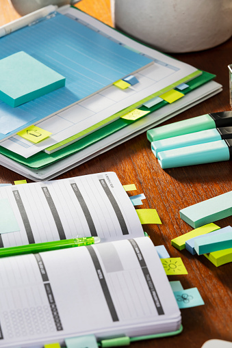 The desk of an organized student. The main focus is on the page markers sticking out of the top of the personal organizer.