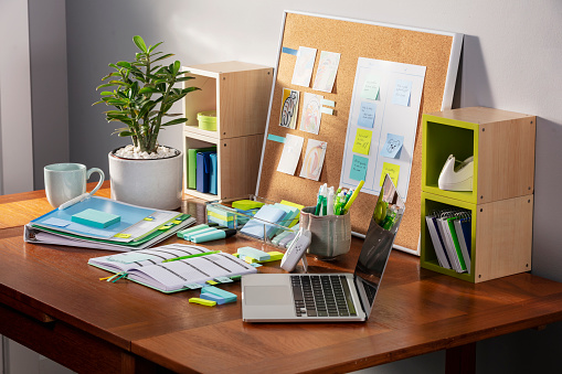 The desk of a student who stays organized with the aid of adhesive notes and page markers.