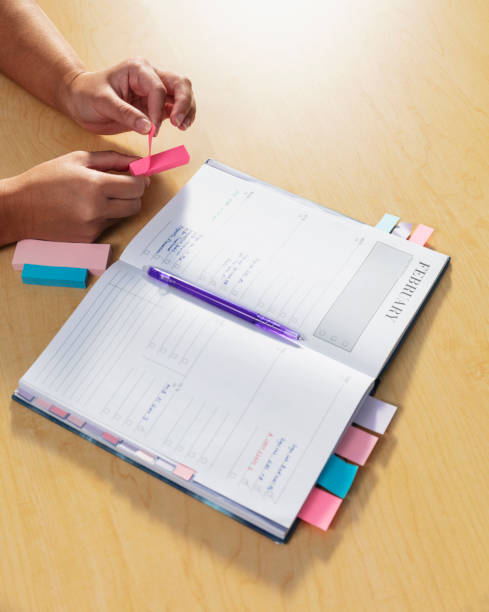 istock Hands of woman using page markers on personal organizer 1958818486
