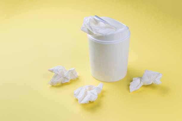 istock A white trash can and scattered paper on a yellow background. 1958856771
