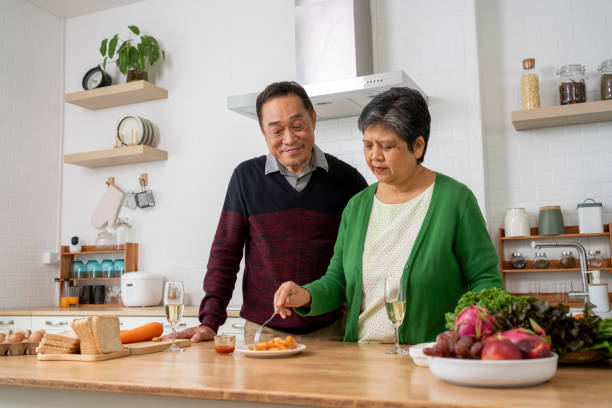 istock Mature couple have spending time with tasting sausage together in kitchen 1958914441