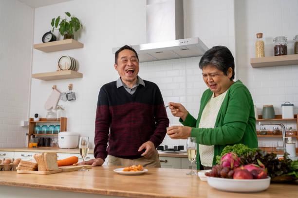 istock Mature couple have spending time with tasting sausage together in kitchen 1958914447