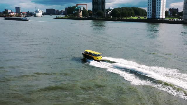 The drone is following a watertaxi going around it in Rotterdam The Netherlands Aerial Footage 4K