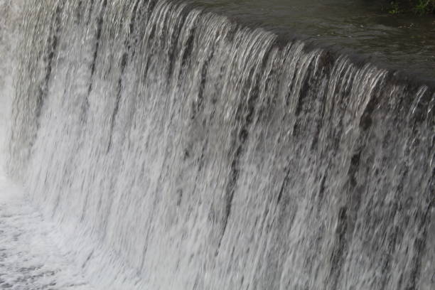 Close-up of a rushing waterfall from a river dam with clear, fresh water.