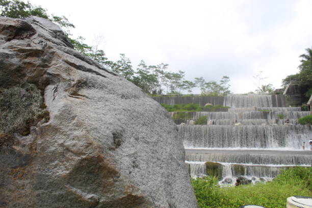 Large gray-black boulder with rushing water