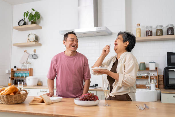 istock Cheerful Mature couple have spending time with fruit together in kitchen 1958990676