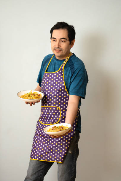 istock man ready to serve a meal with two plates in hands 1958998394