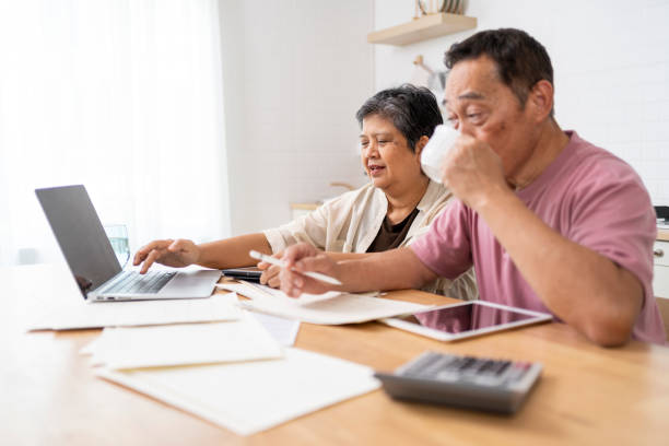 istock Happy Asian senior couple use digital technology device to working at home 1959059241