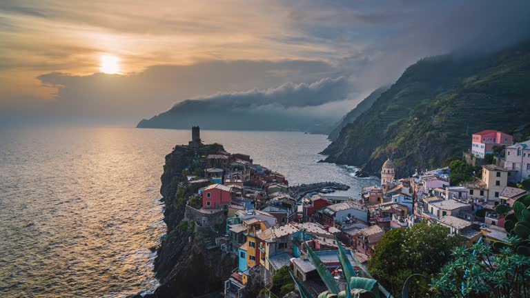 4K Footage Day to Night Time lapse Crowd of People tourist walking and sightseeing attraction at Vernazza Village with lighthouse, one of the five villages in Cinque Terre commune, La Spezia, Italy