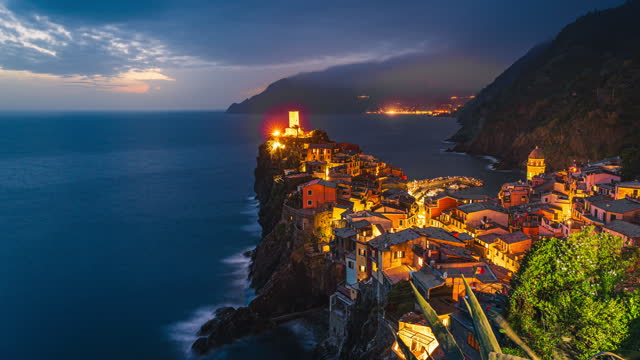 4K Footage Day to Night Time lapse Crowd of People tourist walking and sightseeing attraction at Vernazza Village with lighthouse, one of the five villages in Cinque Terre commune, La Spezia, Italy