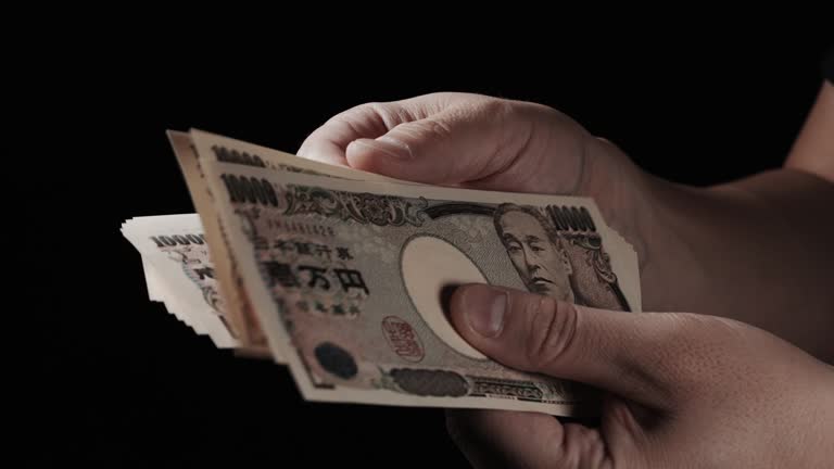 Man's Hand Holding Stack of Bills